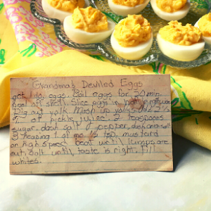 Deviled eggs on platter with handwritten recipe card