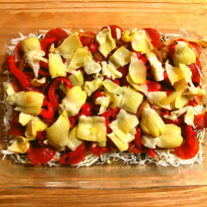 Closeup of assembling layers of antipasto lasagna