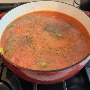 Adding water to beef and vegetable mixture