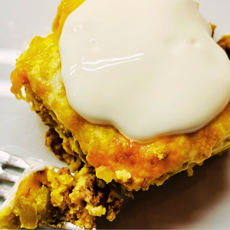 Slice of taco pie on plate with bite on a fork